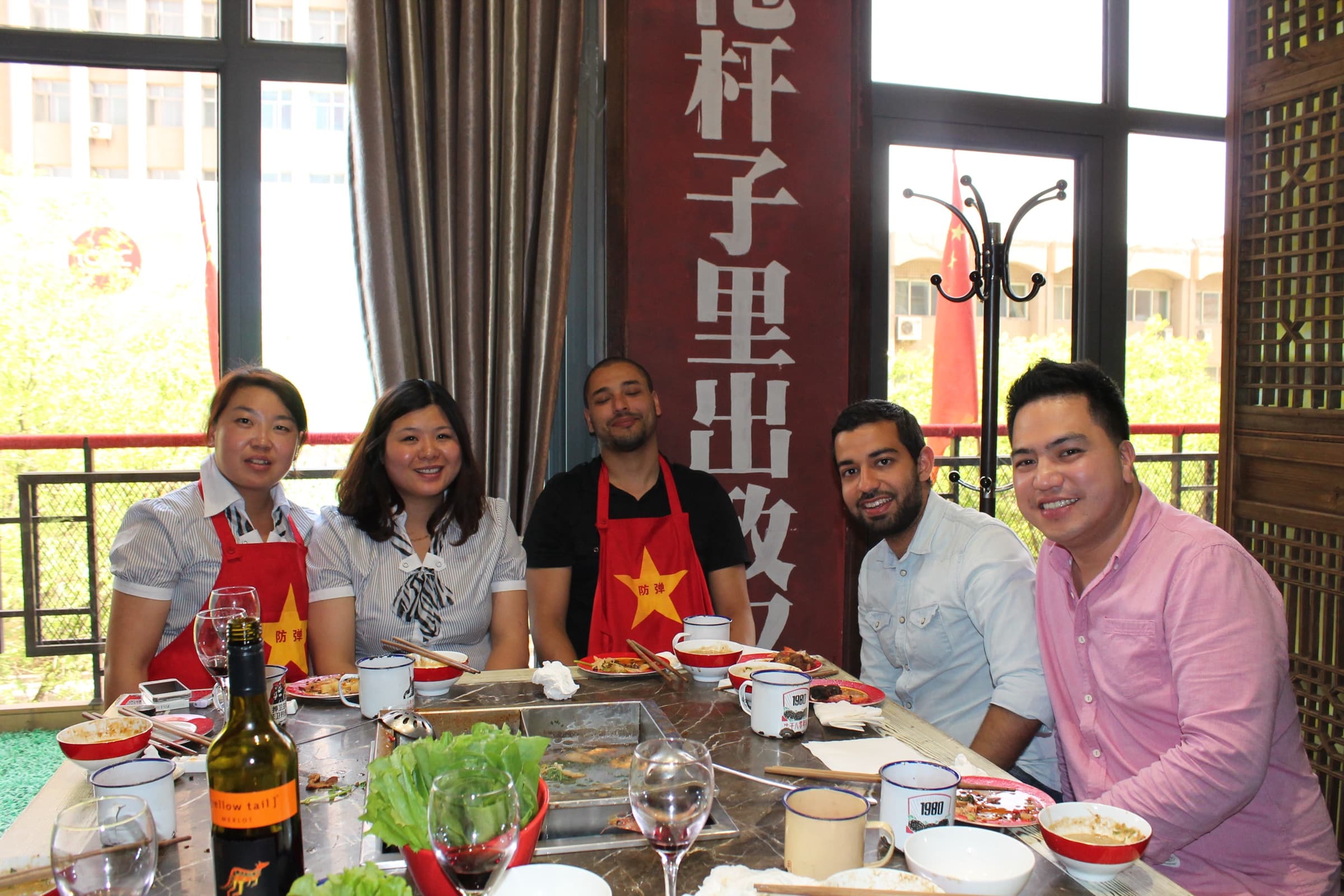 Grande tablée dans un salon de restaurant : une dizaine de convives, chinois et étrangers, autour d’un plateau tournant couvert de plats.